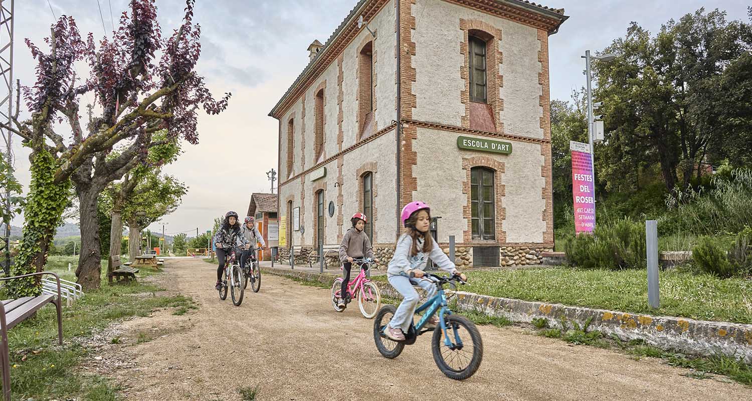 Família en bicicleta la via verda del carrilet, davant de l'escola d'art del Pasteral